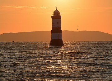 Trwyn Du lighthouse with sunrise above