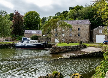 The old water mill and harbour at high tide at Pwllfanogl